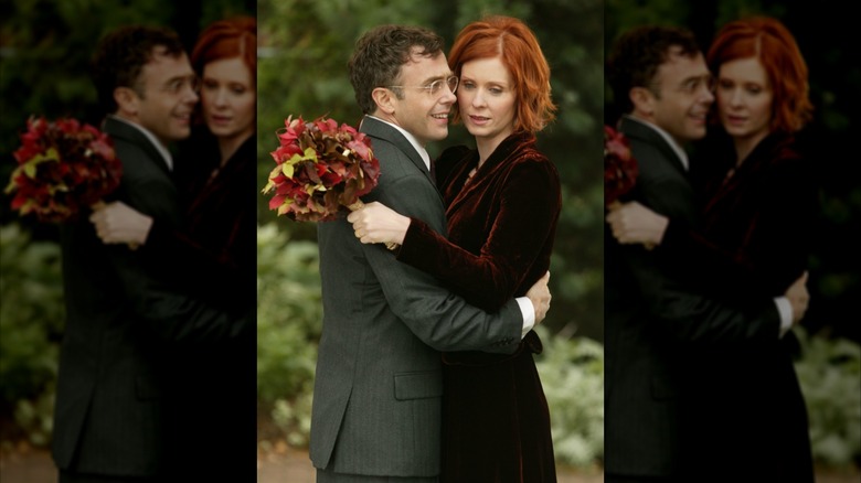 Miranda Hobbes hugging her husband Steve Brady while holding a bouquet