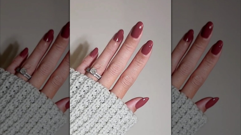 A hand with a dark mauve oval nails