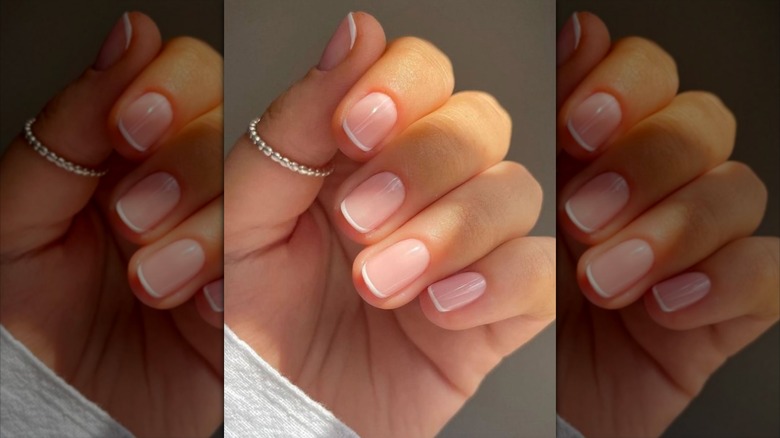 A hand with a micro French manicure