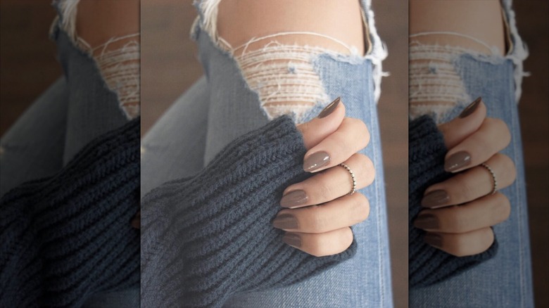 A hand with soft gray nails