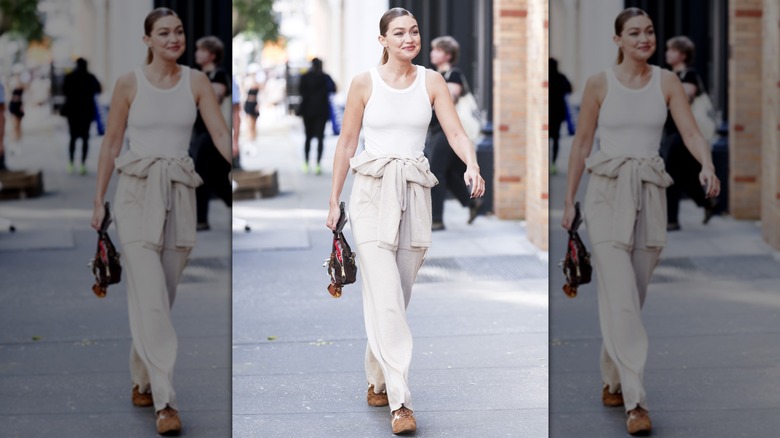 Gigi Hadid walking in New York City in cream loungewear and brown sneakers