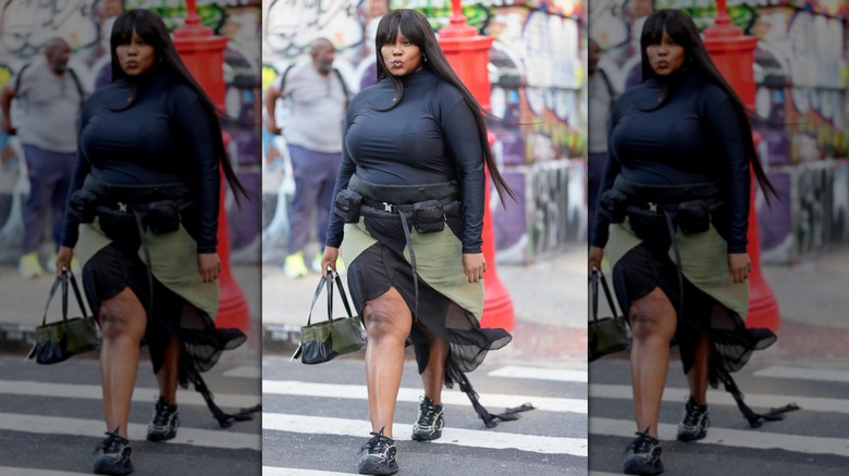 Yseult in New York in a green skirt and a black top