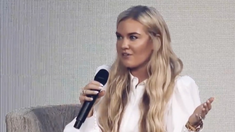 Erika Kirk at a speaking engagement wearing white