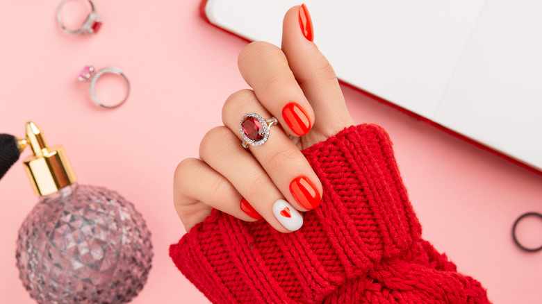Woman in a red sweater with red nail polish