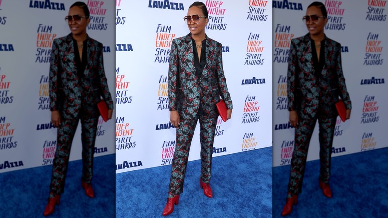 Aisha Tyler wearing a patterned suit, big sunglasses, and heeled boots at a 2024 event