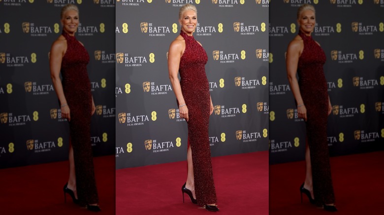 Hannah Waddingham wearing a sparkly red dress that peeps her black heels with a hind slit