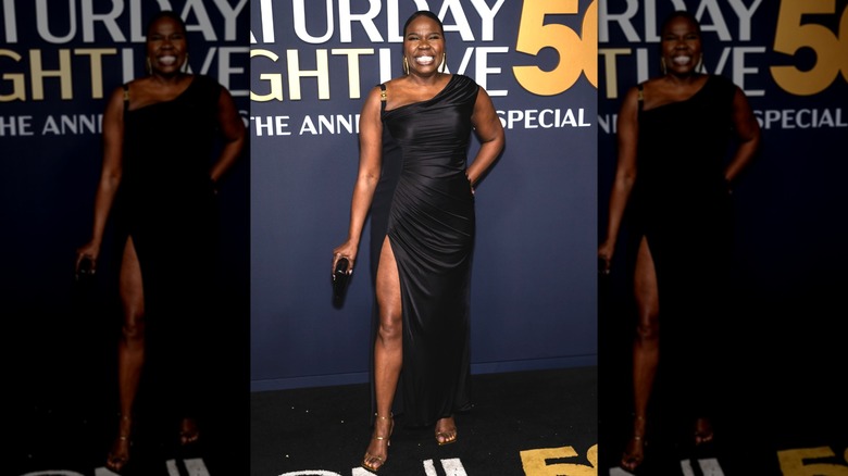 Leslie Jones smiling at the SNL50 celebration while wearing a slitted dress and strappy heels