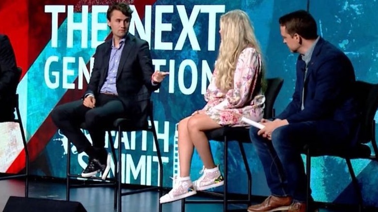 Erika Kirk on stage in a dress and sneakers