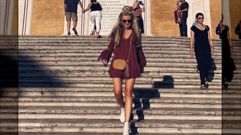 Erika Kirk walking down steps in a dress in Rome
