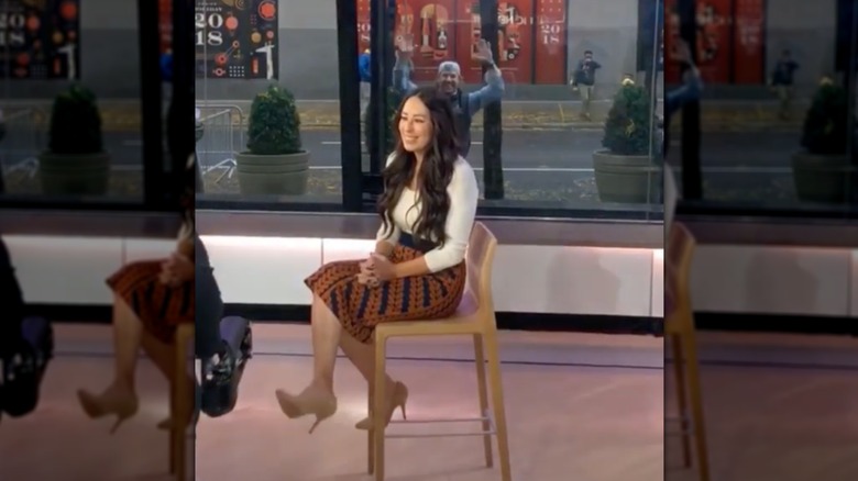 Joanna Gaines on a TV set and Chip Gaines waving outside