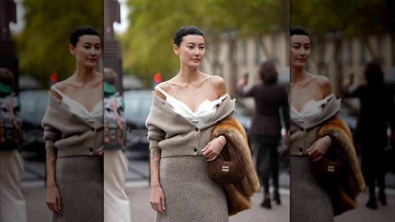 A woman wearing a knit set that is off=the-shoulder