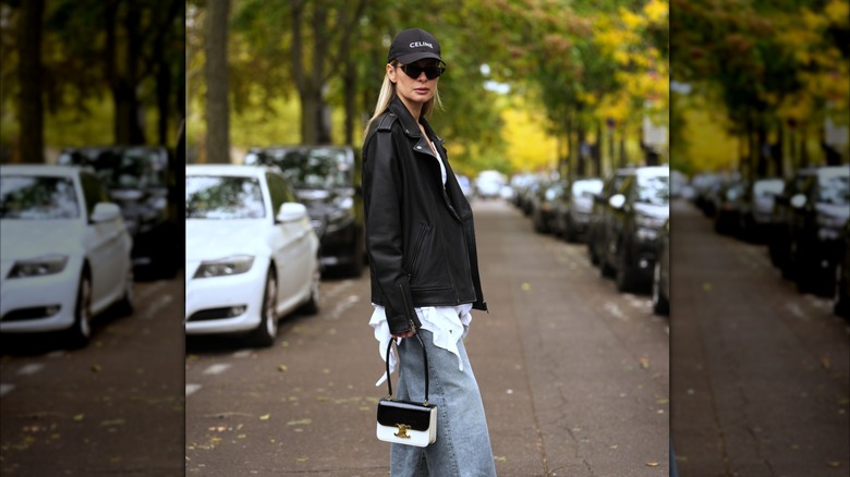 A woman wearing cat-eye sunglasses and a leather moto jacket