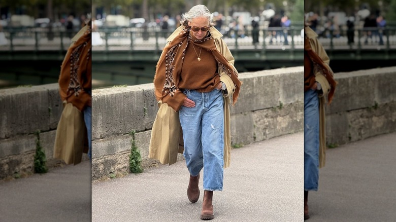 A woman on the streets wearing a pendant necklace and scarf