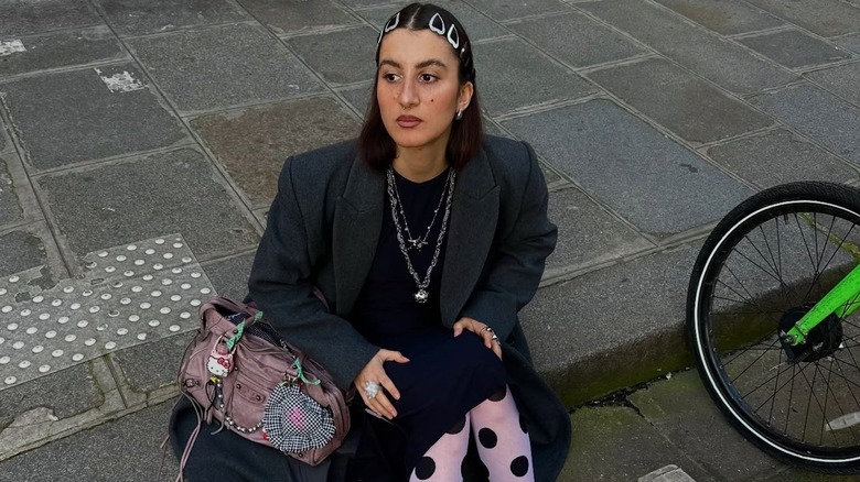 A woman wearing bold jewelry and polka dot tights