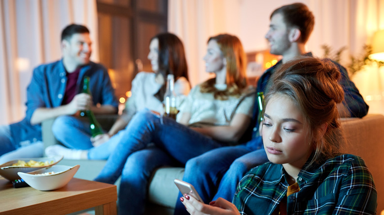 Woman looking at her phone in a group