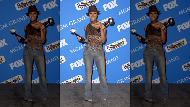 Alicia Keys smiles wearing a leopard print top and bootcut jeans.