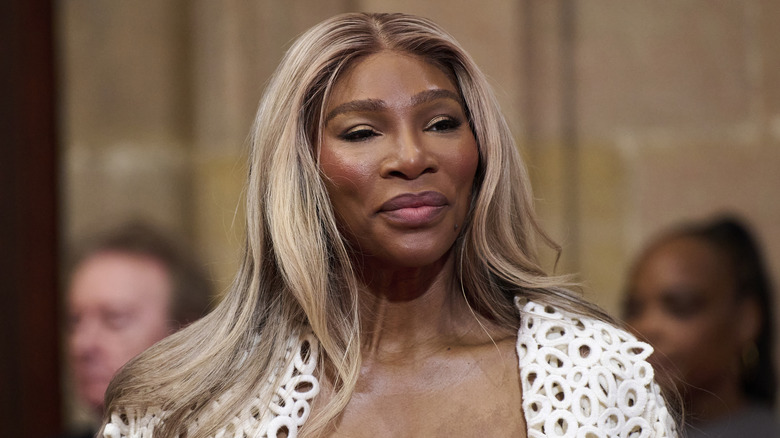 Serena Williams smiles wearing white blazer