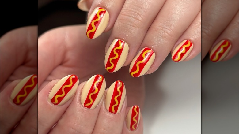 A woman's hands with hot dog inspired nails