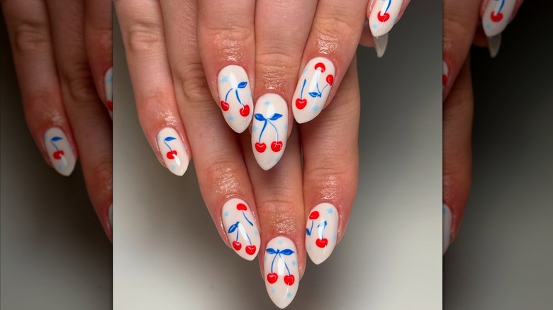 Two hand with a red, white, and blue cherry print manicure