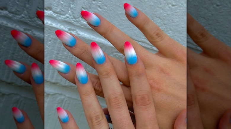 Two hands showing a red, white, and blue ombre manicure