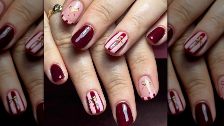 bows and stripes in pink and burgundy nails