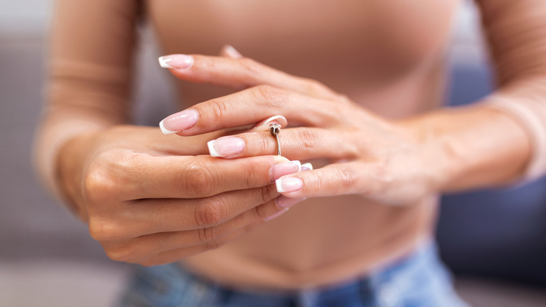 Woman taking off her engagement ring