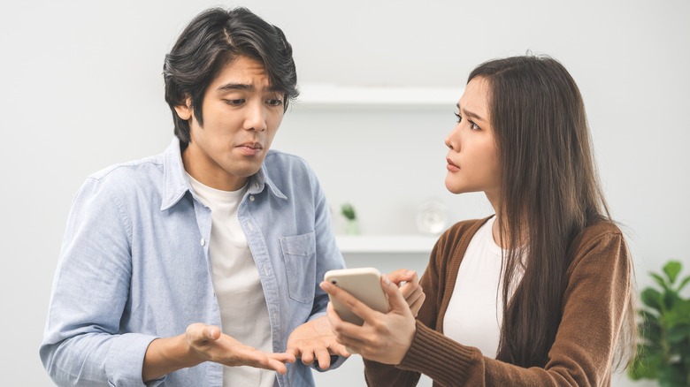 Woman showing man her phone