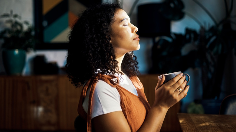 Woman holding mug in sun