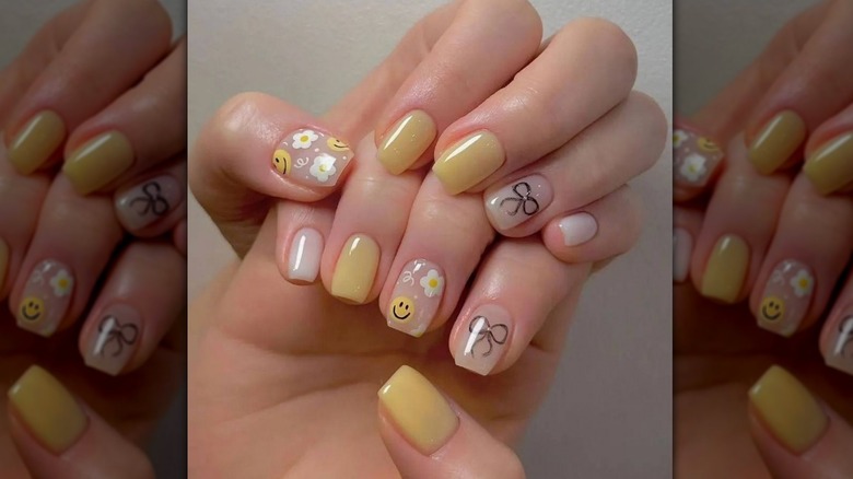 yellow flower smiley face and bow manicure