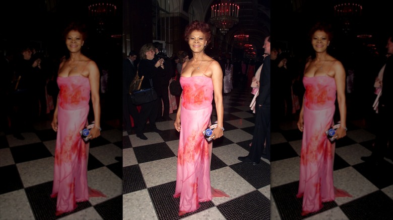 Dionne Warwick smiles wearing a pink maxi dress