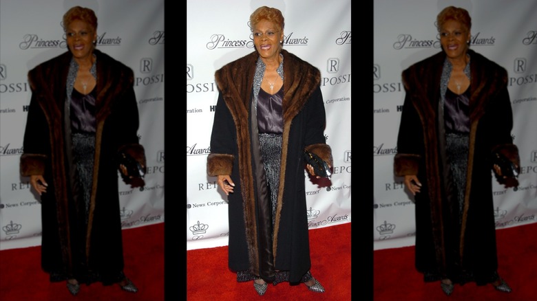 Dionne Warwick smiles wearing an Afghan-style floor-length fur coat