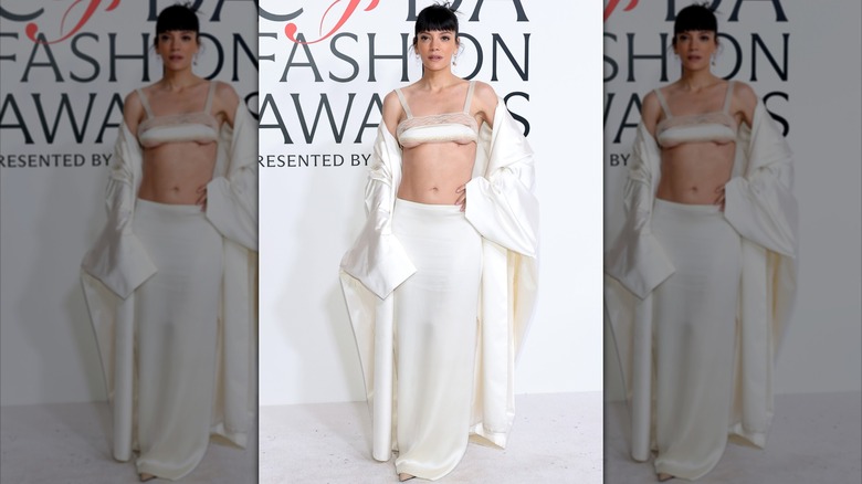 Lily Allen in a white outfit with a white bra top at an event