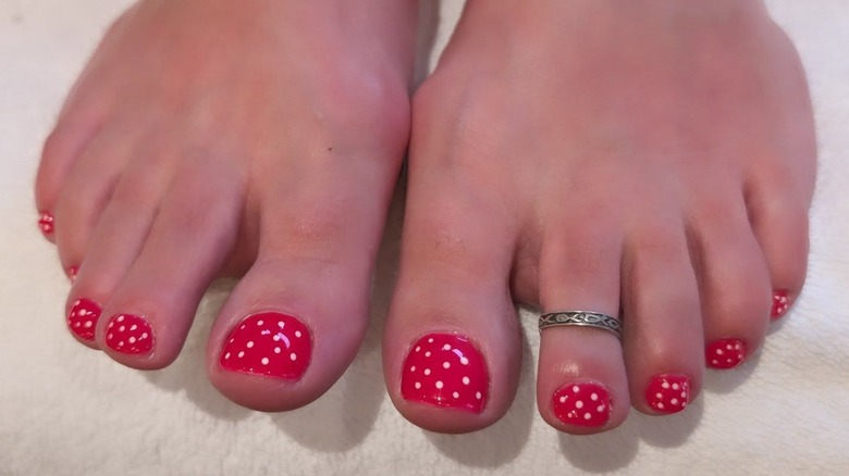A person's feet with a red and white polka dot pedicure