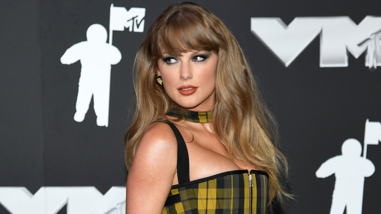 Taylor Swift posing in yellow tartan on the red carpet