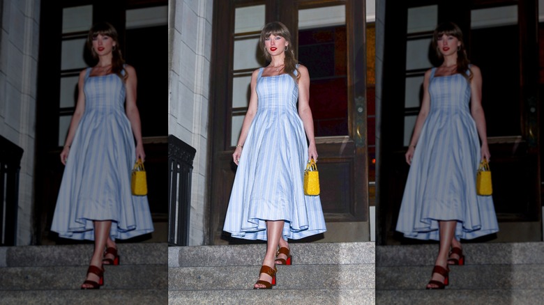 Taylor Swift walks wearing a blue striped summer dress