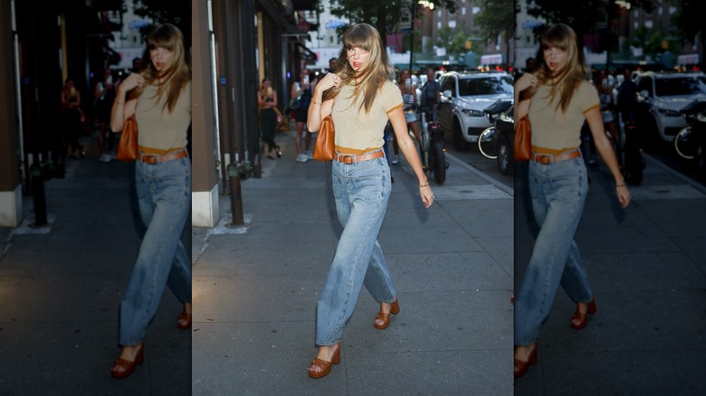 Taylor Swift walks wearing blue jeans and a beige T-shirt