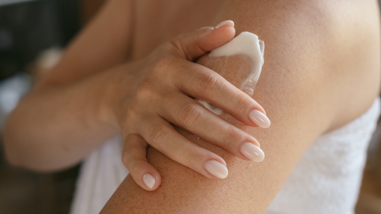 A person applying moisturizer