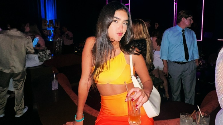 A woman wearing an orange, gradient skirt