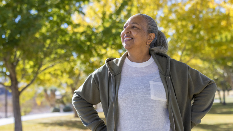 Woman outside smiling hands on hips
