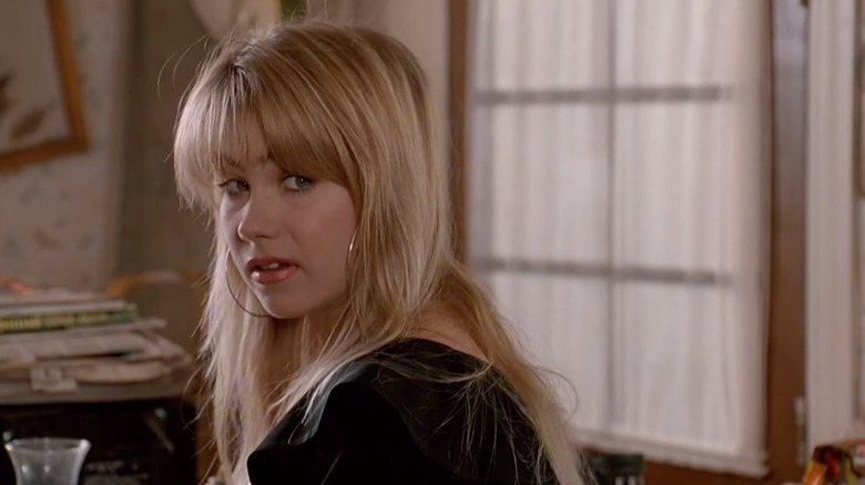 Christina Applegate stares with blond straight hair and hoop earrings