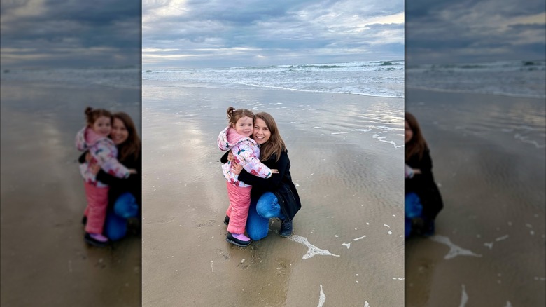 Bindi Irwin hugging her daughter Grace at the beach