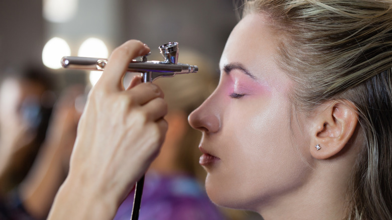 Woman receiving airbrush makeup