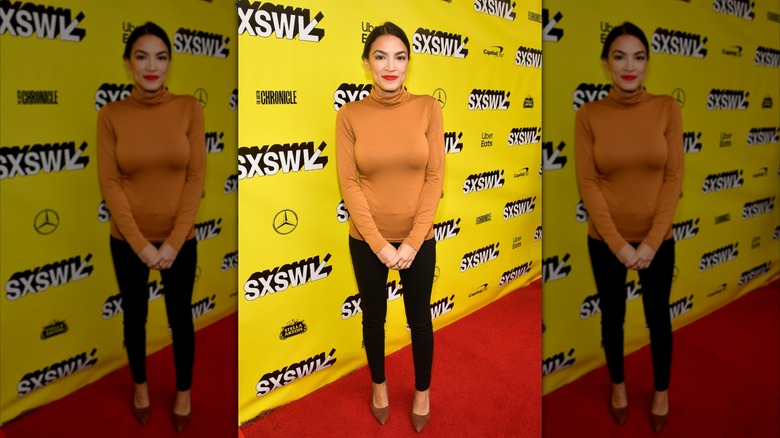 Alexandria Ocasio-Cortez wearing a yellow turtleneck on the red carpet