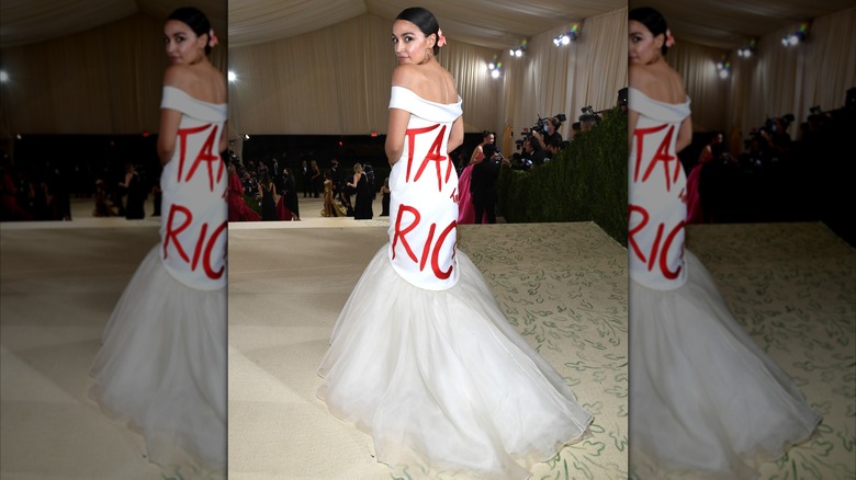 Alexandria Ocasio-Cortez in a white gown with red letters spelling "Tax the Rich"