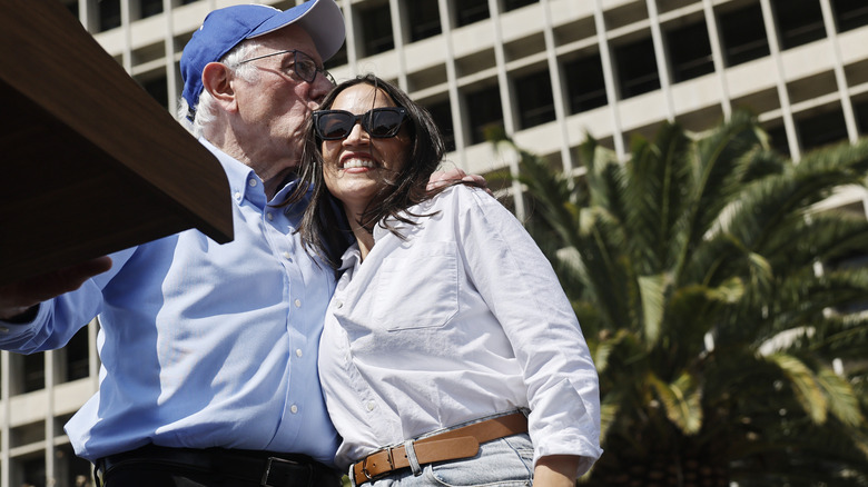 Bernie Sanders hugging Alexandria Ocasio-Cortez at a political rally