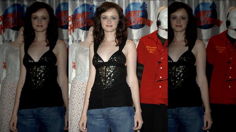 Alexis Bledel in front of mannequins and wearing a black going out top with jeans