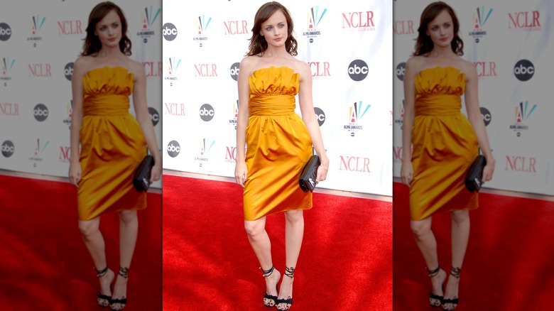 Alexis Bledel on the red carpet in a yellow-orange strapless party dress