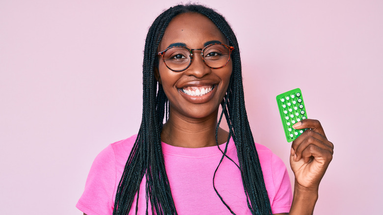 Woman holding a package of birth control pills