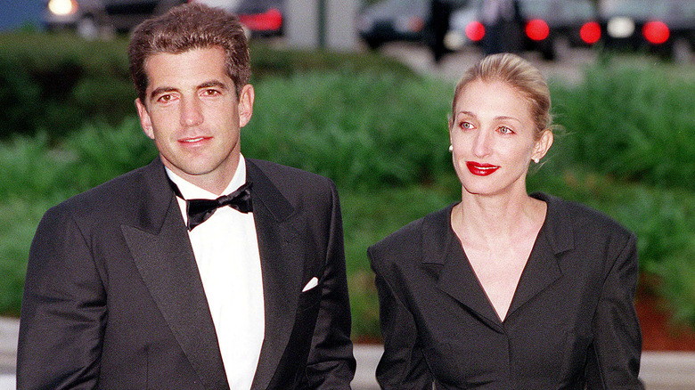 Carolyn Bessette Kennedy standing next to John F. Kennedy Jr., both wearing black