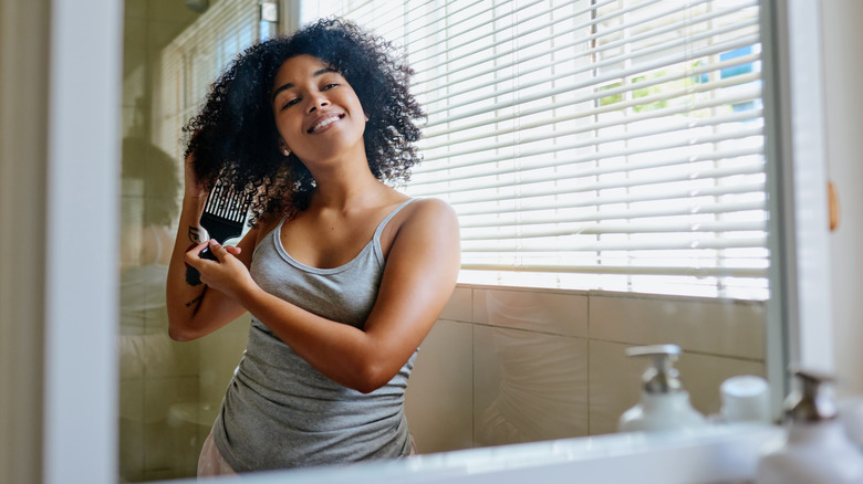 happy woman detangling hair
